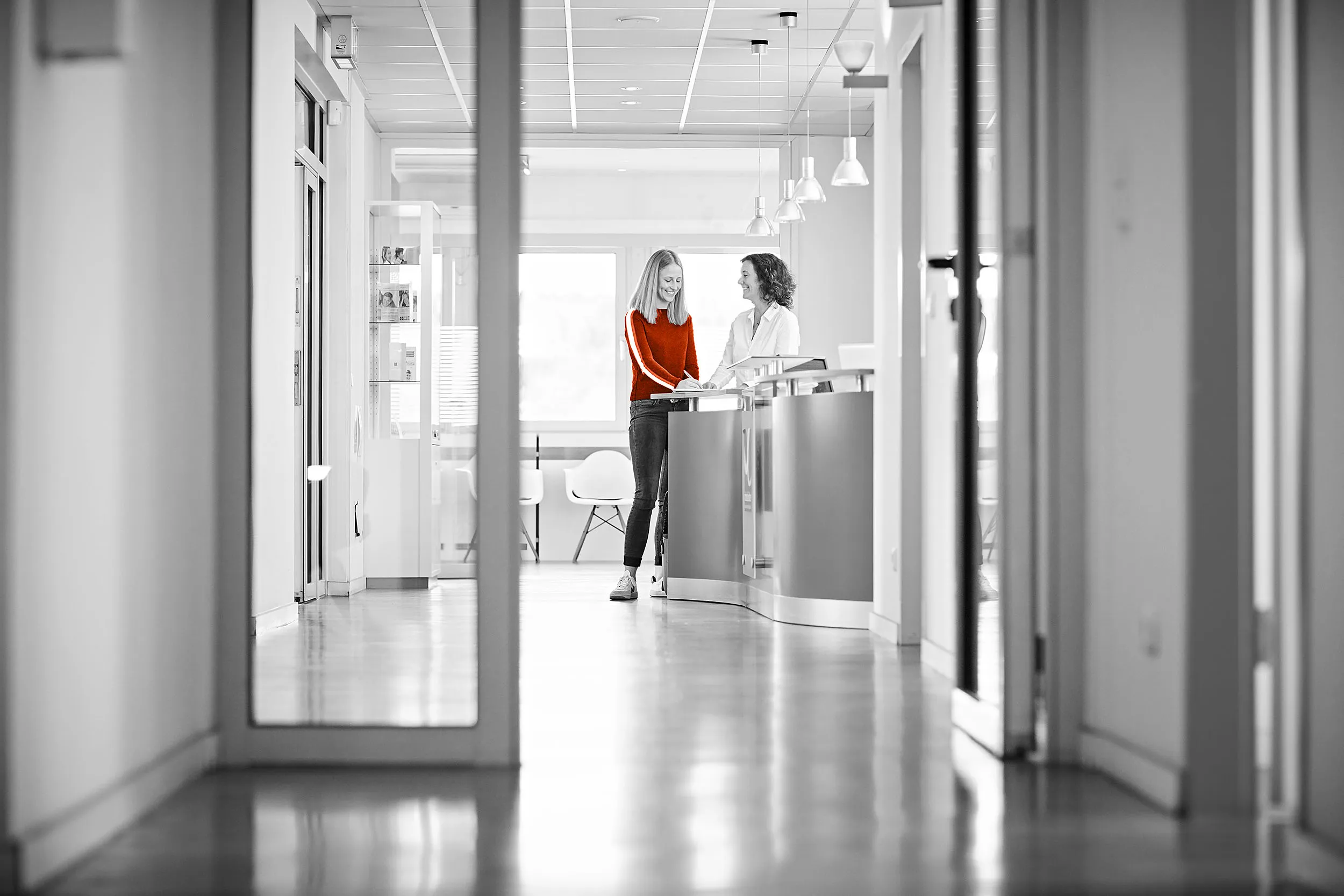 Unsere Mitarbeiterin am Empfang hilft Ihnen gerne weiter! Es ist eine junge Dame am Empfang zu sehen, die gerade ein Formular ausfüllt