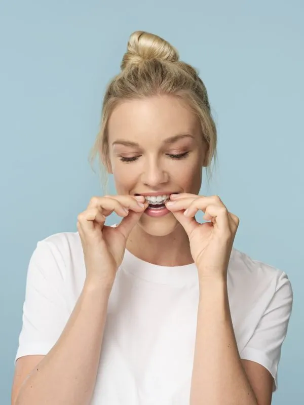 Bild zeigt das Einsetzen einer unsichtbaren Zahnspange bei einer jungen Frau