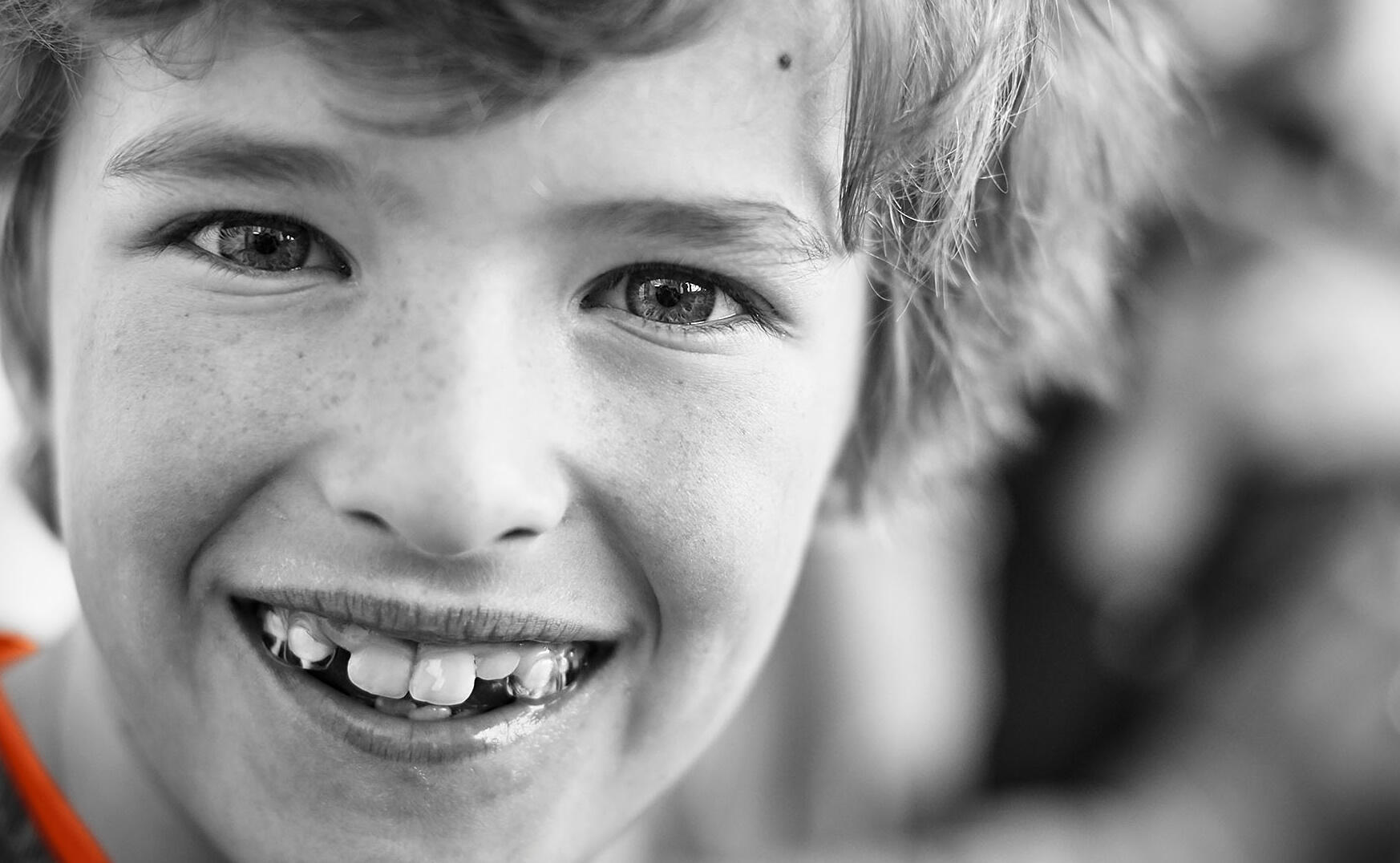 Ein Junge mit Zahnspange lächelt in die Kamera